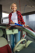 Young smiling woman cleaning the car and feeling good
