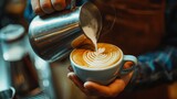 Professional male barista pouring a steamed milk into a coffee cup making a latte art   