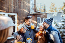 Friends enjoying a winter gathering outdoors with hot drinks