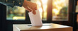 Hand drops ballot into ballot box on election day
