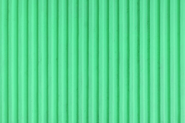 Old pastel green concrete background wall with vertical line ribbed. Stripes as a texture.