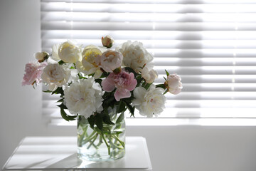 Canvas Print - Beautiful peonies in vase on table near window indoors