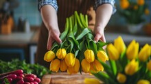 Hands Of Woman Arranging Yellow Tulips At Easter Dining Table
