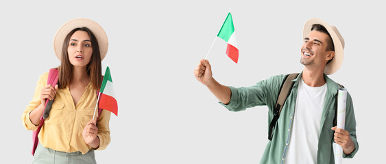 Wall Mural - Young male and female tourists with Italian flags on light background with space for text