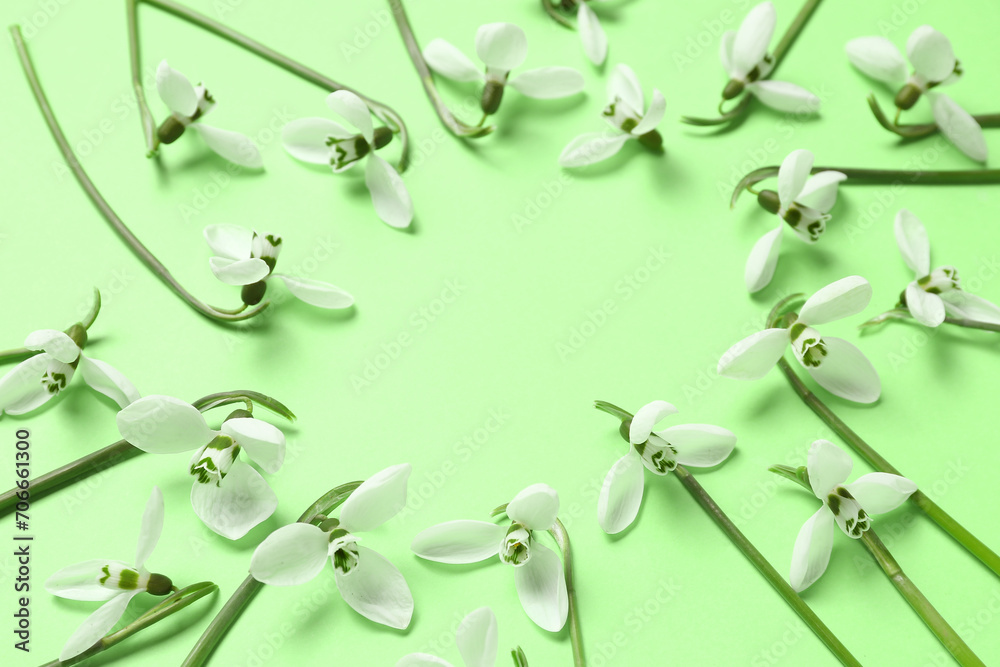 Frame made of beautiful snowdrops on green background