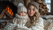 A cozy winter scene with a stunning mother and her bundled-up baby, sitting by a warm fireplace, surrounded by soft blankets and plush pillows, creating a cozy and intimate atmosph