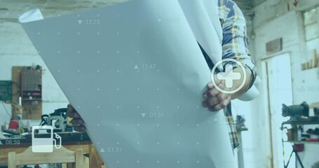 Poster - Animation of fuel and energy icons over mature caucasian male carpenter with blueprints in workshop