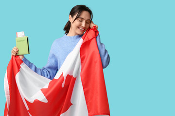 Wall Mural - Pretty young woman with flag of Canada and passport on blue background. Immigration concept