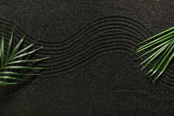 Wall Mural - Tropical leaves on dark sand with lines, top view. Zen concept