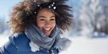 Beautiful Young African American Woman Having Fun Outdoors In The Snowy Winter, Smiling And Looking At The Camera, Wearing A Blue Jacket. Female Person Enjoying Cold Weather Outside, Joyful Lady