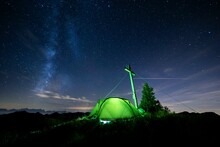 Green Tent With Summit Cross Under A Starry Sky On Portlakopf, Damuels, Bregenzerwald, Vorarlberg, Austria, Europe