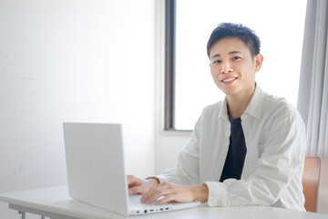 私服でPC作業する爽やかな男性