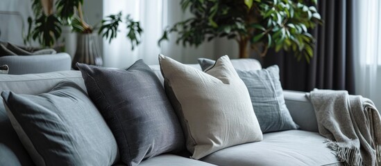 Poster - Trendy knot light grey pillow on comfortable scandinavian couch. with copy space image. Place for adding text or design