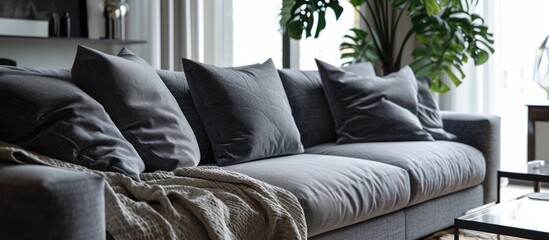 Poster - Trendy knot light grey pillow on comfortable scandinavian couch. with copy space image. Place for adding text or design