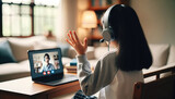 Fototapeta  - Young Girl Virtual Learning Waving Hand Laptop Home Interior - A young girl with headphones waving at the screen during a video call, set in a cozy home environment, ideal for remote learning and mode