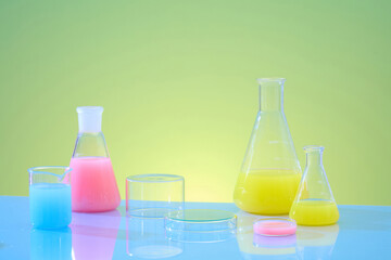 Wall Mural - Lab theme with lab glassware and transparent podiums decorated on green gradient background. Front view, erlenmeyer flasks filled with color solution. Blank space on for product presentation