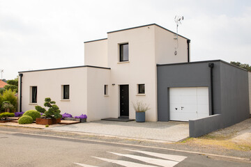 modern cubic white two-storey house with gray garage and garden residential home architecture facade