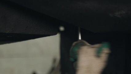 Poster - A mechanic tightens bolts with a wrench on the units and parts of a truck in a repair shop. Close-up.