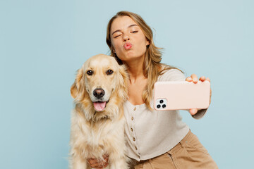 Poster - Young cool owner woman with her best friend retriever wear casual clothes do selfie shot on mobile cell phone hug dog isolated on plain pastel light blue background studio Take care about pet concept