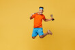 Full body young fitness trainer instructor sporty man sportsman wear orange t-shirt jump high golden medal champion cup award in gym isolated on plain yellow background. Workout sport fit abs concept.