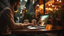 Close-up Of A Cup Of Coffee On The Table Against The Background Of A Man Working Remotely On His Laptop In A Cafe
