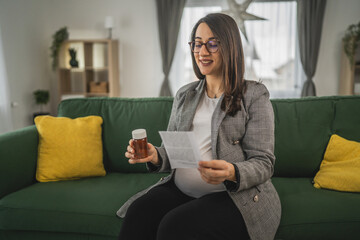 Wall Mural - Expectant woman read leaflet take tablets medication or supplement