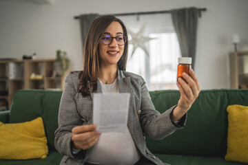 Wall Mural - Expectant woman read leaflet take tablets medication or supplement