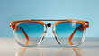 © jbuinac - Sunglasses in an orange brown frame on isolated pastel blue and beige background. Concept of summer fashion, sunn protection, refined, timeless look, vacations accessory.