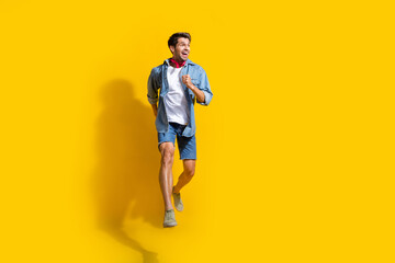 Poster - Full body photo of pleasant man dressed denim shirt shorts run look at proposition empty space isolated on bright yellow color background
