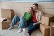 © DimaBerlin - Happy couple man woman hugging dreaming about living in new apartment sitting on floor on kitchen at home. Relocation, moving to flat, family mortgage concept. Spouses enjoying life changes resting.