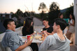 © Prathankarnpap - Group of friends hanging out together talking and having fun on a rooftop party