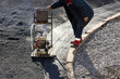 Asphalt compactor compress. A worker of the road service rams asphalt with a portable machine for tamping asphalt.