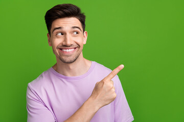 Sticker - Photo of satisfied man wearing purple clothes presenting special black friday sale empty space isolated on green color background