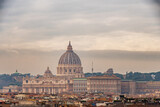 Fototapeta Londyn - View of St. Peter's dome and the rooftops of Rome on a cloudy winter day