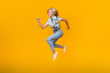 Canvas Print - Full size photo of fast active girl dressed print shirt running look at proposition empty space isolated on yellow color background