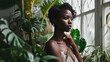 Organic cosmetic concept. Green beauty portrait. Young African American woman in a room with tropical green plants. Spa treatment, concept of body and skin care. Natural cosmetics concept.