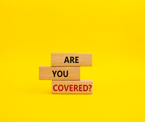 Are you covered symbol. Concept words Are you covered on wooden blocks. Beautiful yellow background. Business and Are you covered concept. Copy space.