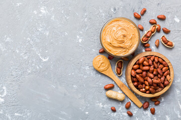 Wall Mural - Bowl of peanut butter and peanuts on table background. top view with copy space. Creamy peanut pasta in small bowl