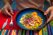 Peruvian-style ceviche plate in outdoor dining, male guest hands ready