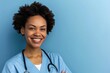 Smiling nurse with a stethoscope, against a calming light blue background.
