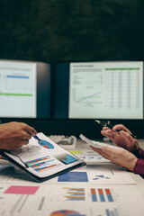 Wall Mural - Business team Two managers work on accounting documents and the team works together to give presentations and help solve problems with accounting documents. Close-up vertical image