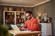 © Jelena - A focused adult male online content writer typing on his laptop in his home office.