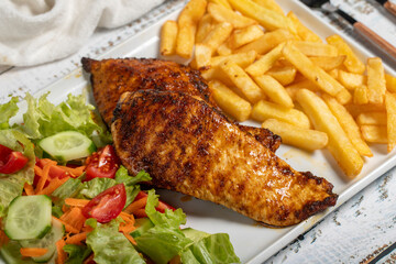 Wall Mural - Grilled chicken. Grilled chicken breast with salad and fries on a white background. Close up