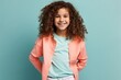 Portrait of a smiling little girl with curly hair over blue background