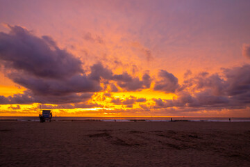 Wall Mural - Extremely colorful and sunset and beautiful cloudscape in Venice Beach with a silhouetted lifeguard shack.
