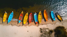 Aerial View Of Colorful Kayaks Lined Up On A Sandy Beach By Turquoise Waters.