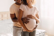Cropped Shot Of Young African American Expectant Couple Embracing Indoor