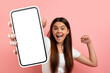 © Prostock-studio - Overjoyed teen girl celebrating success, showing big phone