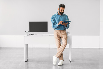 Aufkleber - Engaged indian businessman reading tablet by his workstation