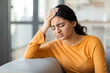 © Prostock-studio - Depressed young indian woman suffering from headache, pressing her forehead with hand